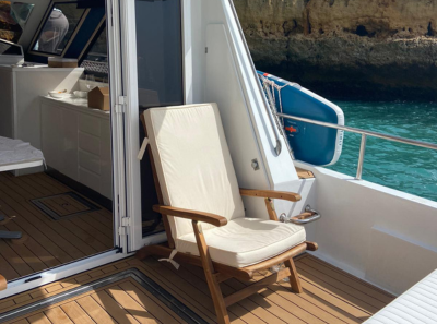 Aft deck with cushioned bench, teak floor and the anchor mark.