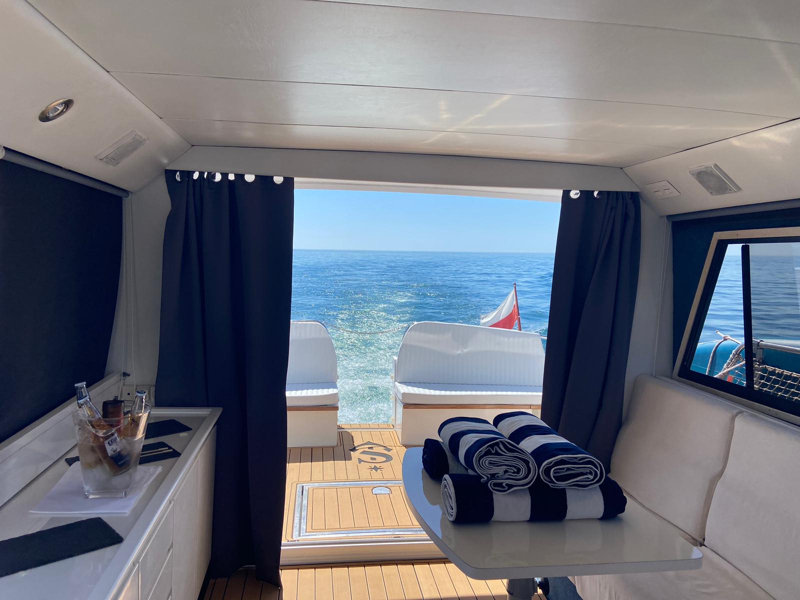 Flybridge with white cushioned seating and folded towels.